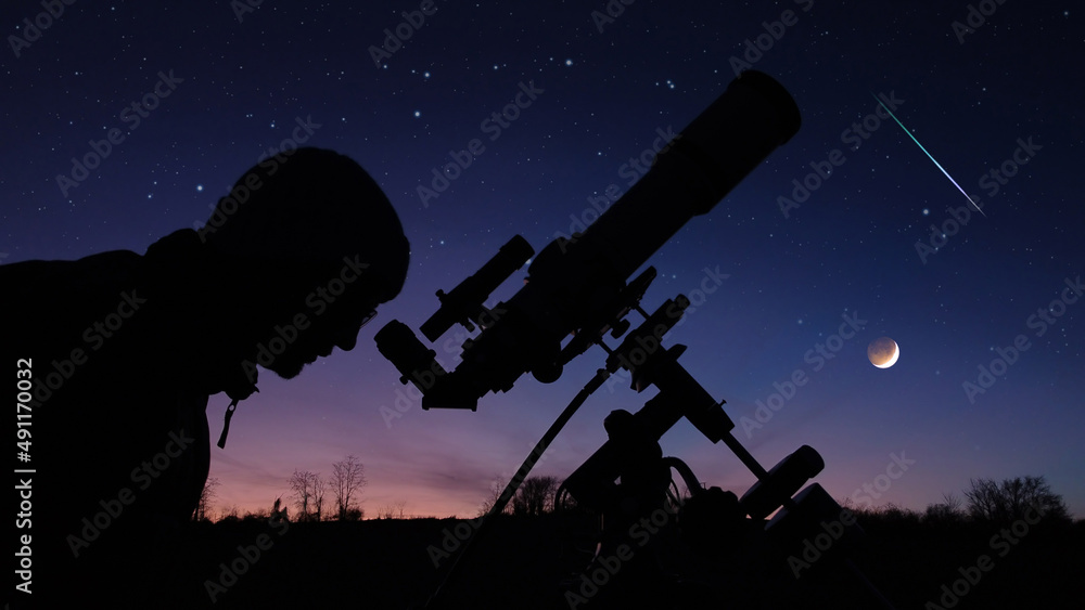 Silhouette of a man, telescope and countryside under evening skies. Silhouette of a man, telescope and countryside under evening skies.