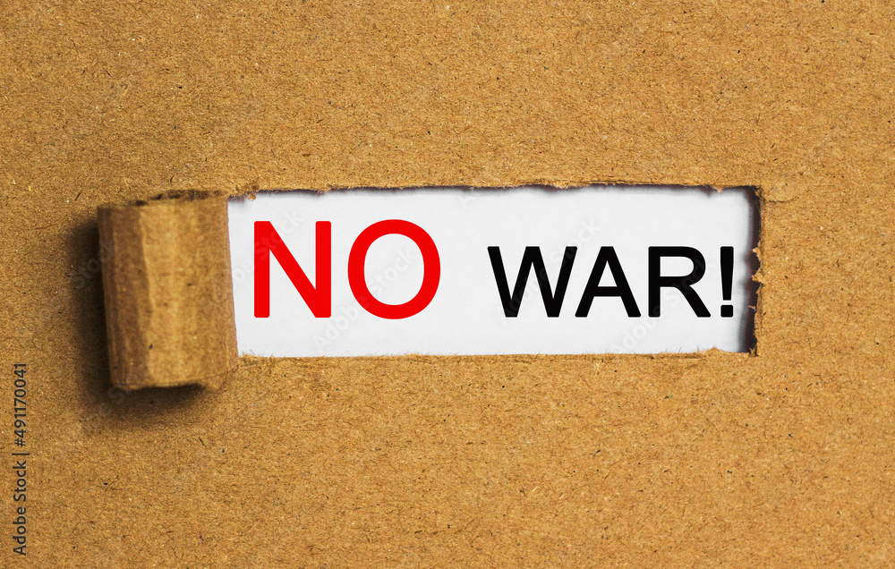 Obraz premium The text NO WAR behind torn brown paper