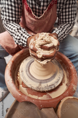 Skilled African American potter shaping ceramic ware photo