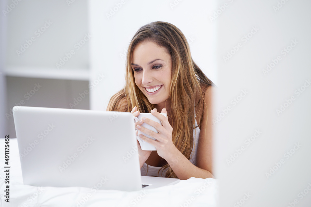 Connected from the comfort of home. A beautiful woman using her laptop from the comfort of her bed. Connected from the comfort of home. A beautiful woman using her laptop from the comfort of her bed.