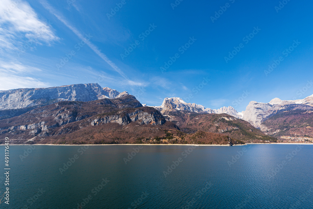 Panoramic view of lake Molveno with the mountain range of Brenta Dolomites in winter. National Park of Adamello Brenta. Molveno village, tourist resort in Trentino Alto Adige, Trento, Italy, Europe.