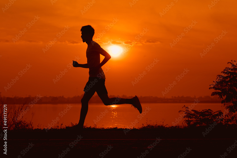 young male runner while practicing running On the road around the park around Thawatchai Reservoir Roi Et Province