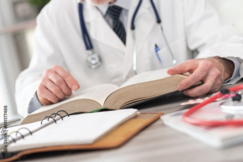 Doctor reading a textbook Doctor reading a textbook