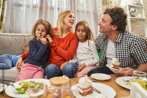 Portrait of smiling parents sitting with daughters and having fun