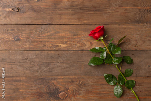 Romantic background with red rose on wooden table  top view. Copy space
