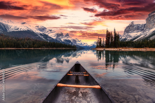 Leinwand Poster Spirit Island with canoe and colorful sky over canadian rockies on Maligne Lake