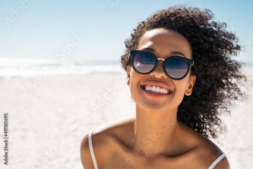 Beautiful black woman at beach wearing sunglasses photo