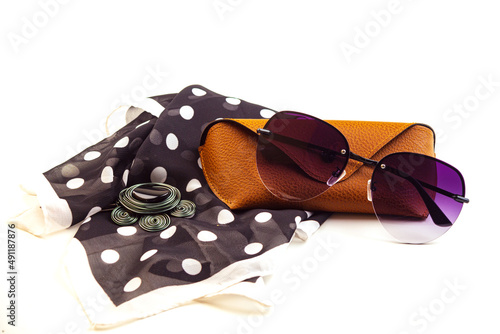 fashionable women's sunglasses. A case for storing glasses. they are lying on a woman's scarf. women's jewelry. pink glass. beautiful shape. on a white isolated background. Metal frame.