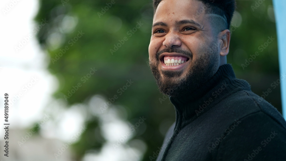 A young black man laughing and smiling portrait face a hispanic latin Brazilian person turning head to camera A young black man laughing and smiling portrait face a hispanic latin Brazilian person turning head to camera