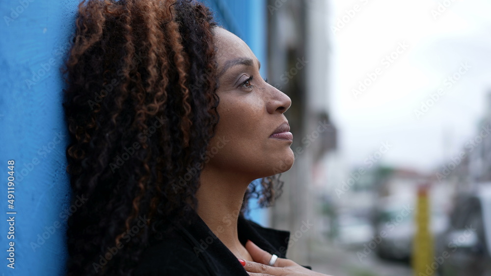 Fototapeta premium A hopeful black African woman smiling looking at sky having FAITH