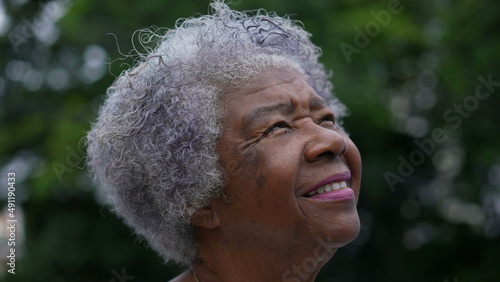 A hopeful senior woman portrait smiling outside looking at sky