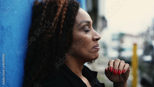 A desperate African woman outside in street feeling anxious
