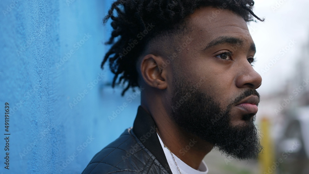A contemplative black man standing in street A contemplative black man standing in street