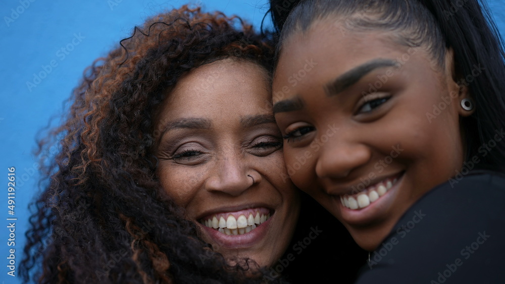 A black mother and daughter faces together smiling A black mother and daughter faces together smiling