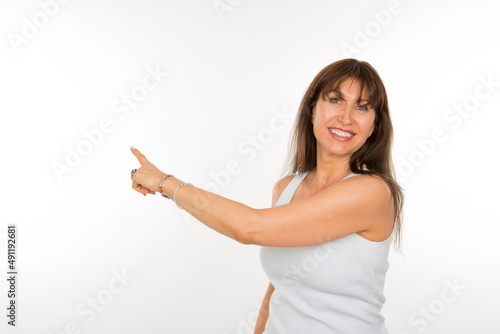 portrait senior woman pointing with index finger to the side smiling isolated on white background