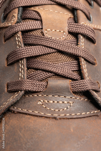 Close-up view of shoelace on brown leather walking shoe