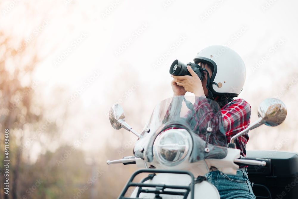 Young girl riding a motor scooter on road.Travels by scooter slow life in the countryside on vacation. Young girl riding a motor scooter on road.Travels by scooter slow life in the countryside on vacation.