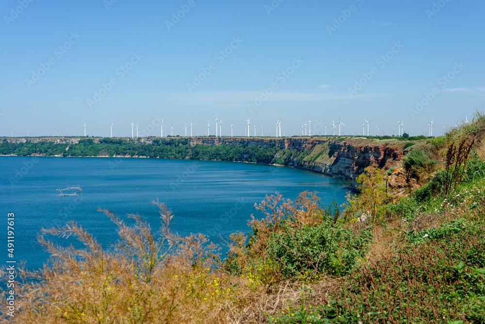 Sea, cliff, landscape of Bulgaria. Large number of windmills. Electricity and ecology. Nature and beautiful weather.
