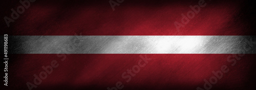 Foto The Latvian flag on an old looking background