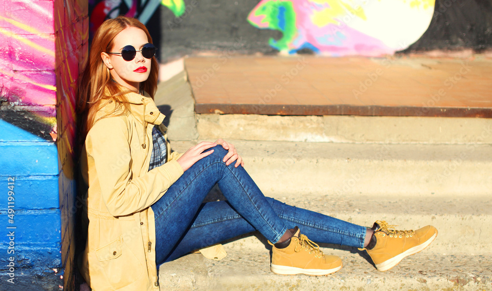 Obraz premium Fashion portrait of beautiful stylish blonde young woman on city street over colorful graffiti background