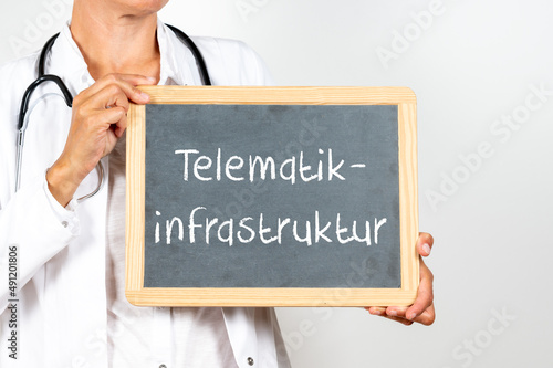 Ärztin mit einer Tafel auf der Telematikinfrastruktur steht