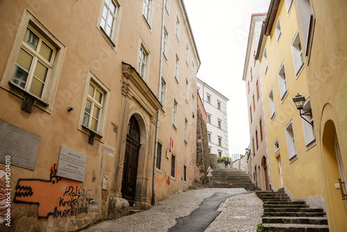 Linz, Austria, 29 August 2021: Narrow picturesque street, Facade of colorful buildings in historic center of medieval city, renaissance and baroque houses at summer sunny day, stairs, wooden windows