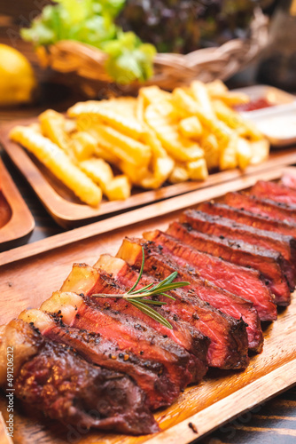 Beef steak serve on wooden plate with rosemary herb and pepper, fresh grilled meat food made for dinner, picanha or sirloin beef fillet cut with salt and vegetable