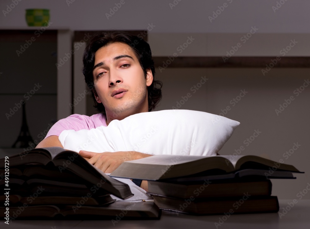 The male handsome student preparing for exams late at home The male handsome student preparing for exams late at home