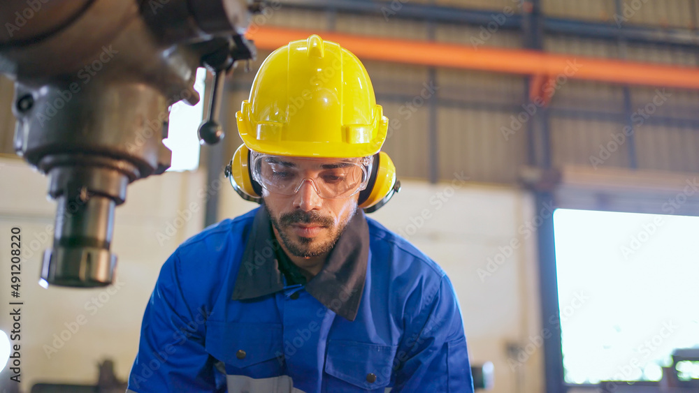 Factory engineer checking or maintenance machine. Wearing safety helmet and glasses to prevent accident. Worker inspector equipment and repair. Industrial, inspector and technology concept.