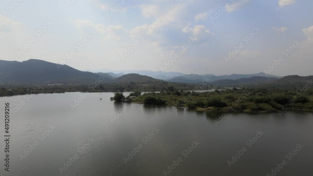 Aerial View of the Landscape Over a Lake with Rising Up Drone Shot Revealing the Horizon and Mountains in the Background. Aerial View of the Landscape Over a Lake with Rising Up Drone Shot Revealing the Horizon and Mountains in the Background.