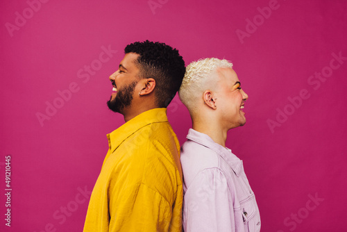 Cheerful gay couple standing together in a studio
