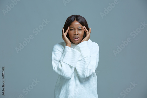 Stressed african american woman suffer from headache, migraine pain, massaging temples, grimacing