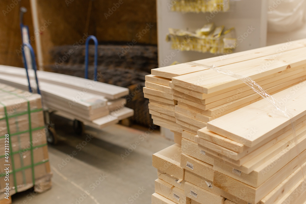 Wooden boards, slats, lumber in the foreground. Stacked lumber. Folded wood. Boards in the warehouse Wooden boards, slats, lumber in the foreground. Stacked lumber. Folded wood. Boards in the warehouse
