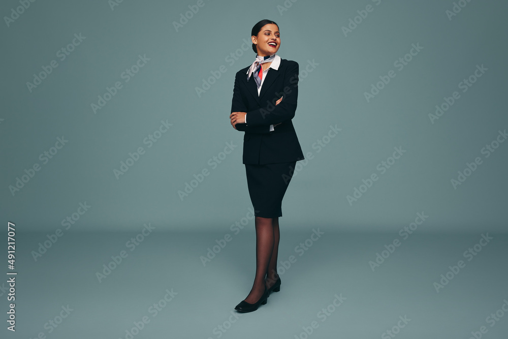 Happy flight attendant smiling cheerfully in a studio Happy flight attendant smiling cheerfully in a studio