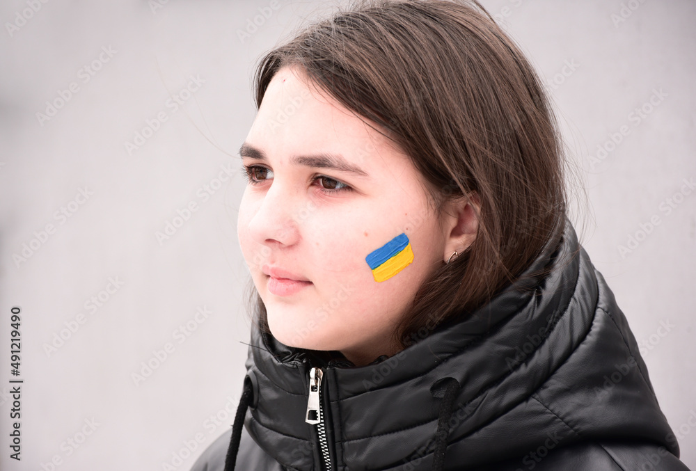 Portrait of Ukrainian girl with national flag on cheek, patriot of Ukraine teen girl. Portrait of Ukrainian girl with national flag on cheek, patriot of Ukraine teen girl.