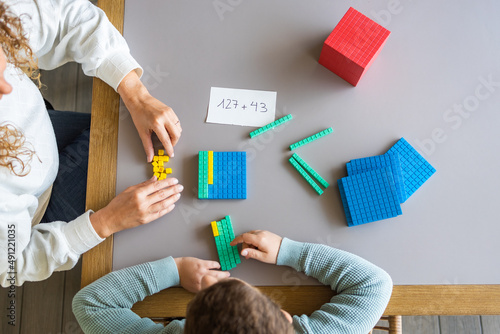 Konstfotografi Mother teaching her son math with base 10 method at home