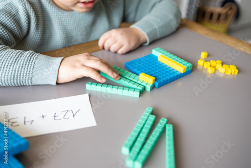 Foto Little boy using the base 10 method to do addition at home