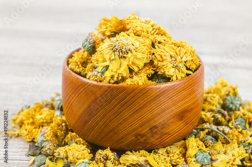 Dried Chrysanthemum tea in wooden bowl.