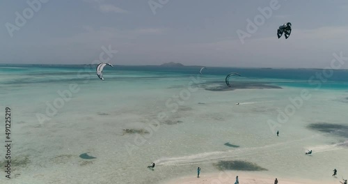 Group of kiters sailing  in Caribbean island. Drone shot pan left over Saqui Saqui in Los Roques photo