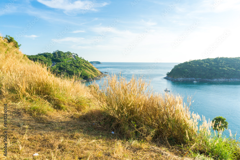 Sunset on Phuket island viewpoint turquoise sea water with yellow grass