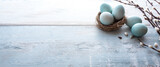 Easter eggs with spring branches on wood Easter eggs with spring branches on bright vintage wood. Horizontal easter background with space for text.