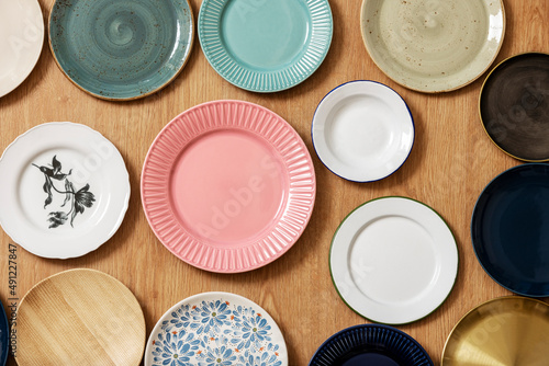 Set of assorted empty porcelain plates of different shapes and colors