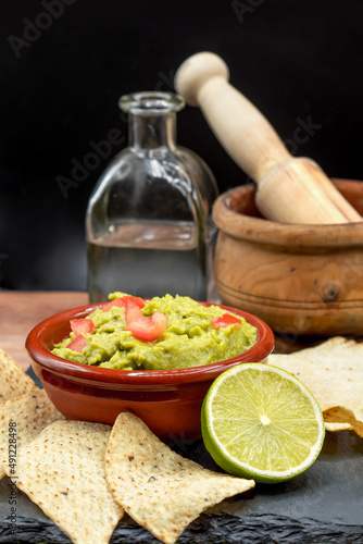 Homemade Organic Guacamole, tequila and Tortilla Chips. Selective focus.