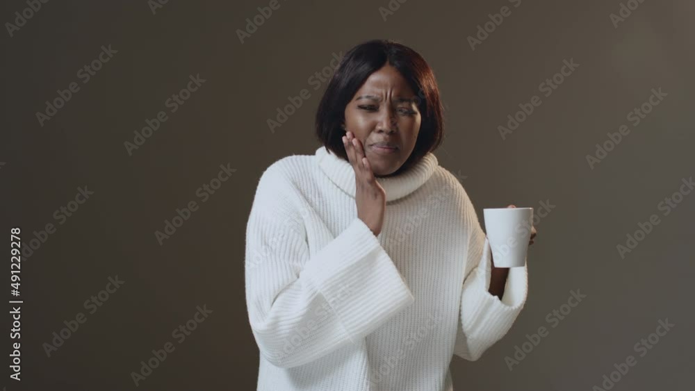 Tooth ache. African american woman drink hot tea, suffer acute sudden