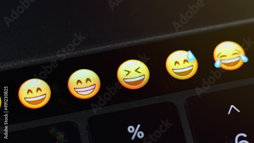 Selects the mock emoji from a range of other emoji on the laptop and sends the emote