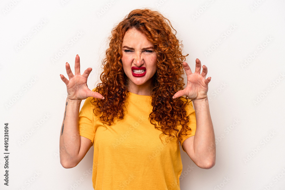 Young ginger caucasian woman isolated on white background showing claws imitating a cat, aggressive gesture. Young ginger caucasian woman isolated on white background showing claws imitating a cat, aggressive gesture.