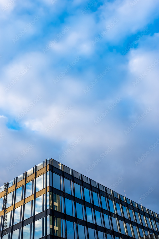 Facade of a modern apartament building against a blue sky background. Photo taken at late afternoon on a sunny day. Facade of a modern apartament building against a blue sky background. Photo taken at late afternoon on a sunny day.