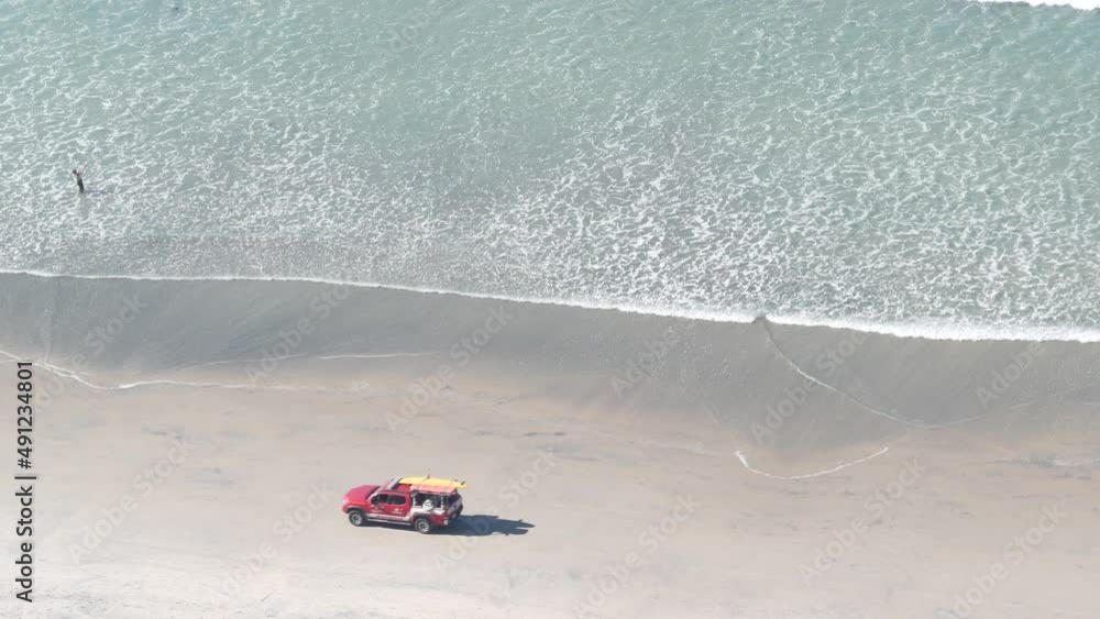 Lifeguard red pickup truck, life guard auto on sand, California ocean beach USA. Rescue pick up car on coast for surfing safety, lifesavers vehicle and sea waves tide from above. Torrey pines cliffs. Lifeguard red pickup truck, life guard auto on sand, California ocean beach USA. Rescue pick up car on coast for surfing safety, lifesavers vehicle and sea waves tide from above. Torrey pines cliffs.