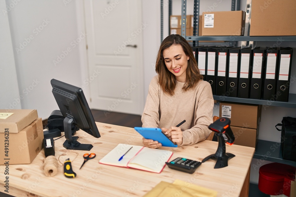 Young woman ecommerce business worker using touchpad at office Young woman ecommerce business worker using touchpad at office