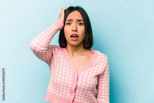 Young hispanic woman isolated on blue background being shocked, she has remembered important meeting. © Asier